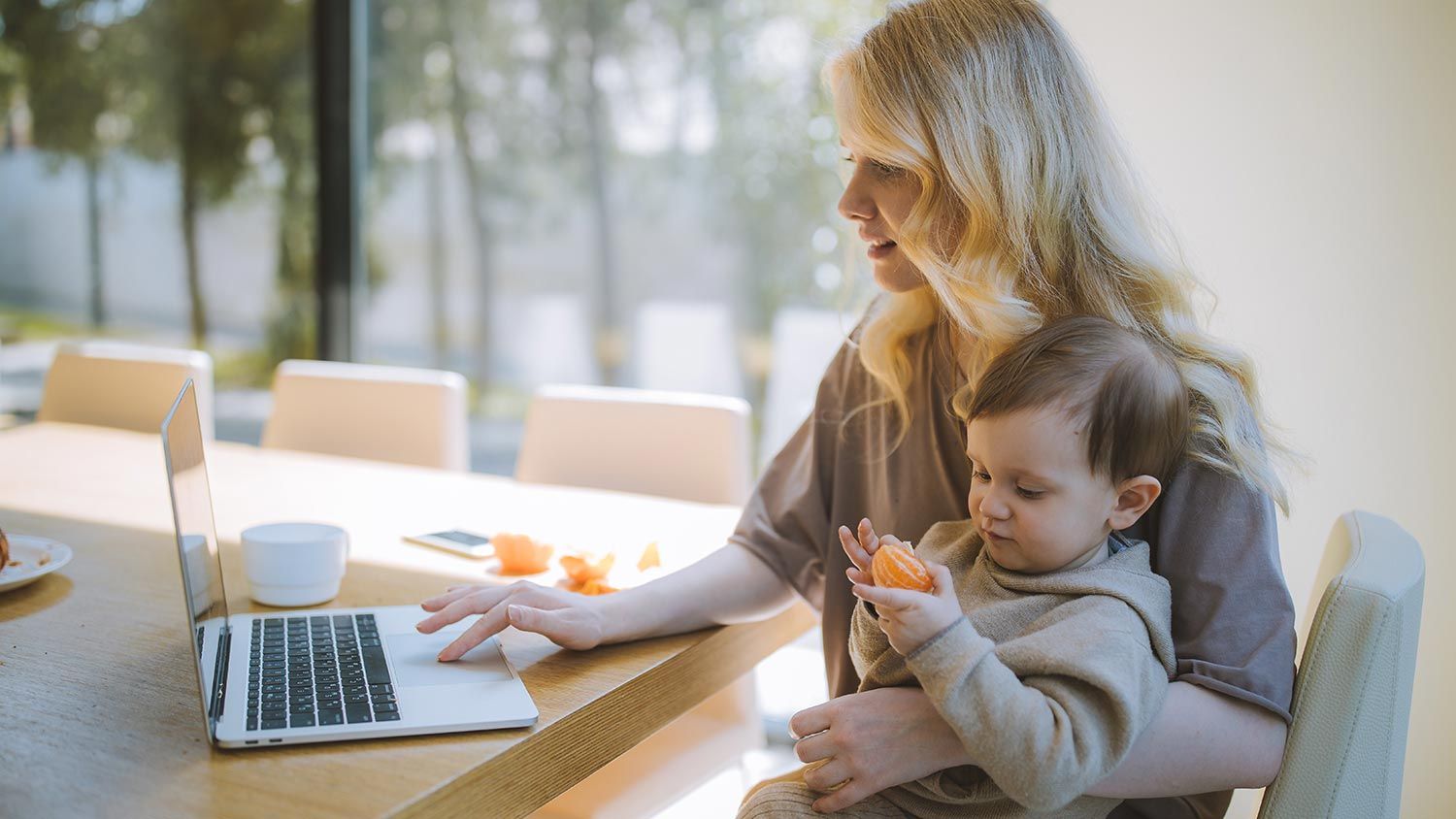 Woman with a baby working on a computer