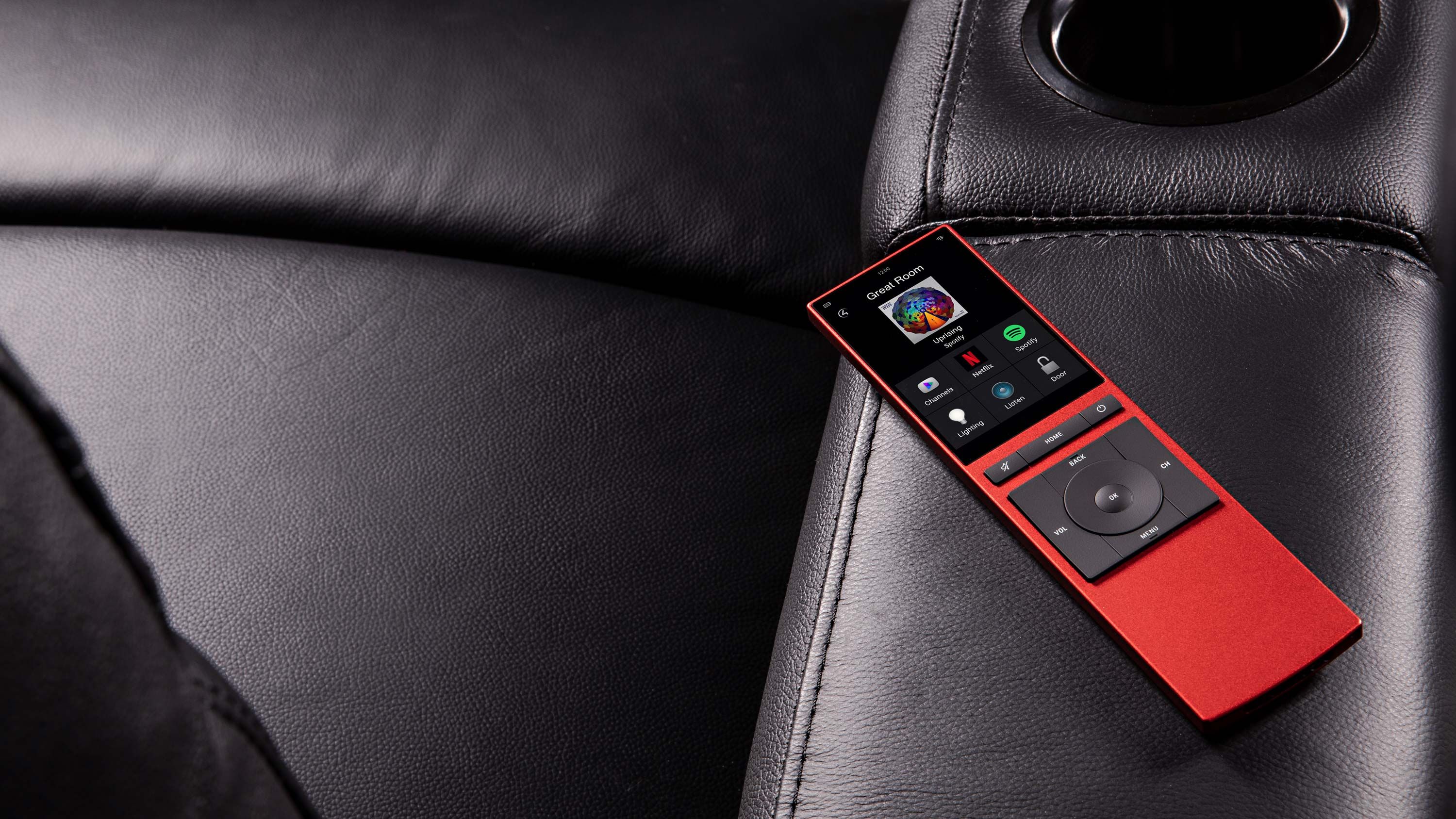 Red control4 neeo remote on black couch